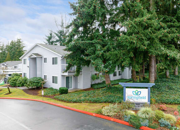 a white house with a sign and trees at Springfield, Renton, WA