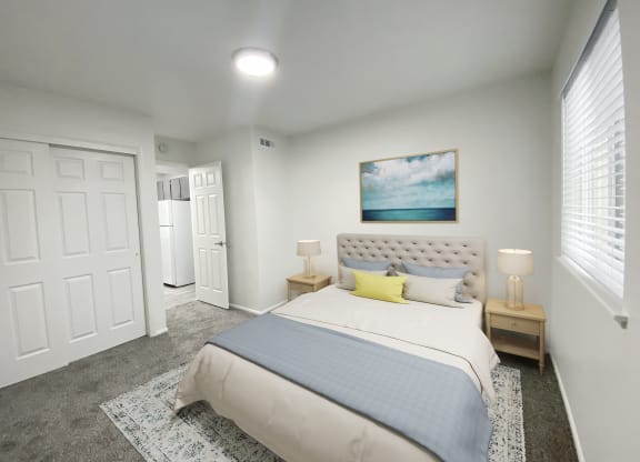 Carpeted bedroom with double sliding door closet on left and large window on right. Staged with queen-size bed and side tables.at Summit, Pocatello, 83201