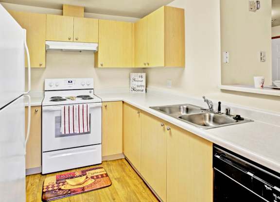 A kitchen with a white refrigerator, white stove, and a white sink.