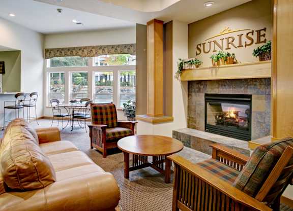 A living room with a fireplace and a sign that says Sunrise.