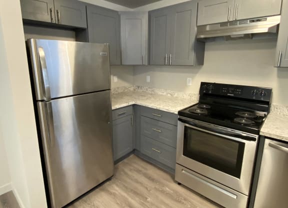 a kitchen with stainless steel appliances and marble counter tops  at The Lakes Apartments, Washington, 98837