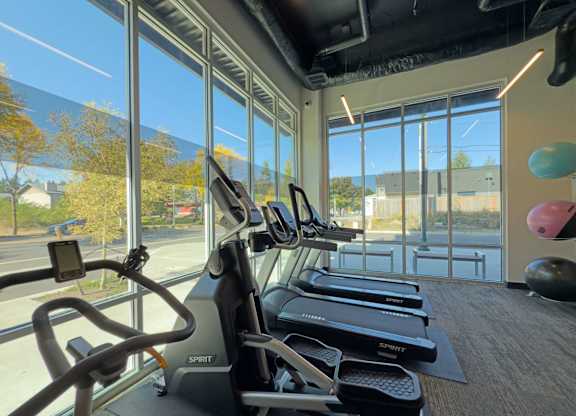 A gym with treadmills and exercise balls at The Duo Apartments in University Place, WA.