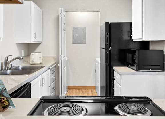 A black stove top in a kitchen with white cabinets at The Overlook Apartments in Post Falls, ID.