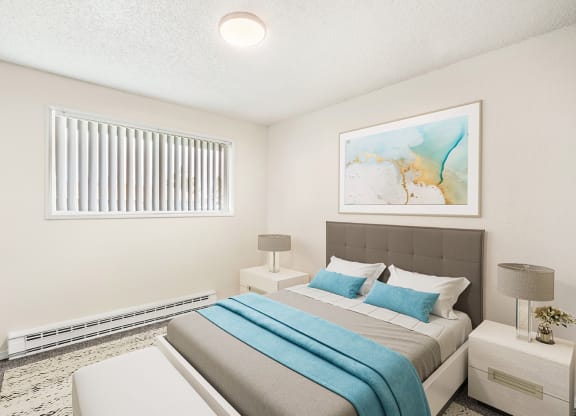 Spacious bedroom with white walls, taupe carpets, and a large window with white blinds. Staged with a bed, side tables, a bench, and art.at Wildflower, Washington, 99336