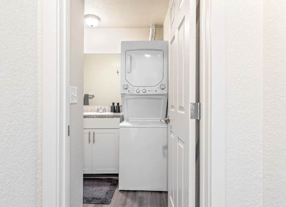 Hallway leading to a stacked washer and dryer in a bathroom at Wildflower Apartments in Kennewick.