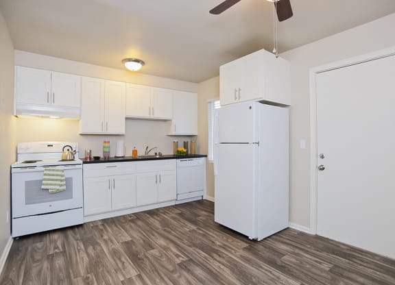 an empty kitchen with white cabinets and a white refrigerator  at Woodhaven, Everett, 98203