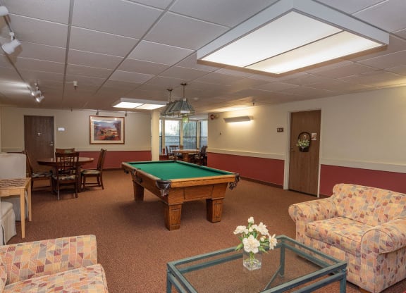 a game room with a pool table and couches at Hilltop Commons Senior Living, Grass Valley, 95945