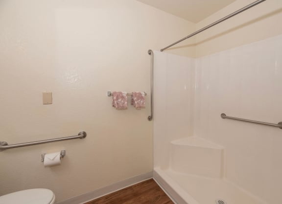 a bathroom with a shower and a toilet in it at Hilltop Commons Senior Living, Grass Valley, CA
