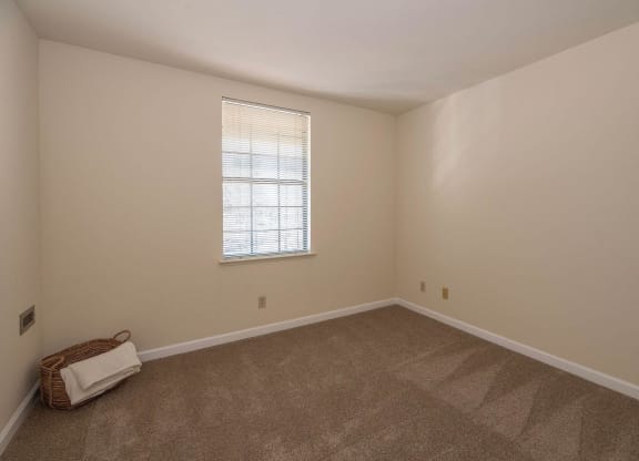an empty living room with carpet and a window at Hilltop Commons Senior Living, Grass Valley, CA