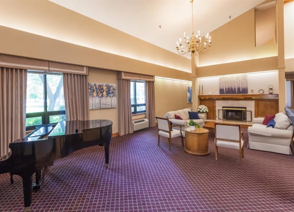 a living room with couches and chairs and a fireplace at River Commons Senior Living, Redding