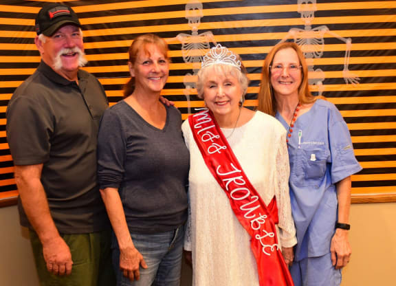 a group of people posing for a picture with a red ribbon at River Commons Senior Living, California, 96002