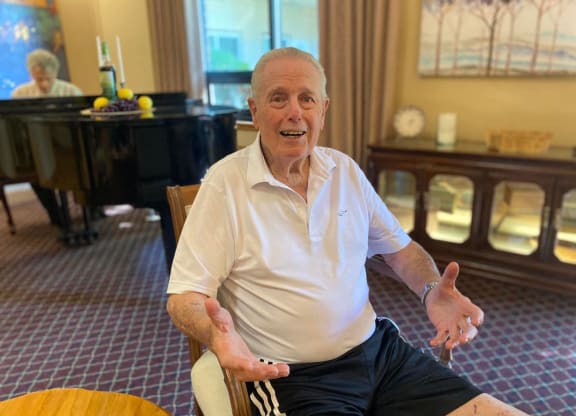 an older man sitting in a chair in a hotel room at River Commons Senior Living, California, 96002