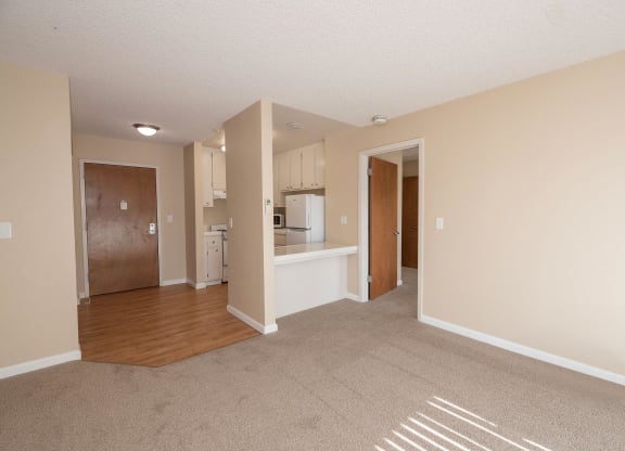 an empty living room and kitchen with an open floor plan at Roseville Commons Senior Living, Roseville