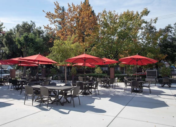 a patio with tables and umbrellas at Roseville Commons Senior Living, Roseville, CA 95678
