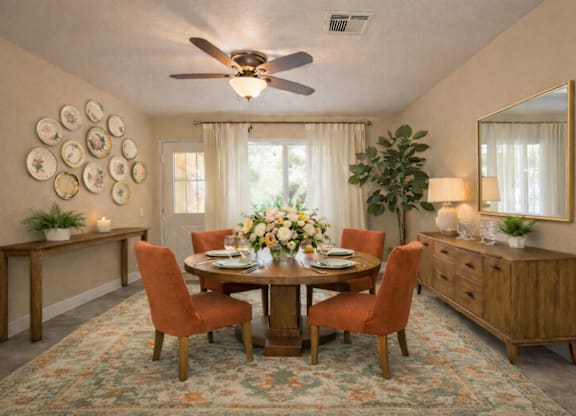 Formal dining room with orange upholstered chairs and wood credenza at Castle Vista Senior Duplex Community Apartments, Atwater, CA