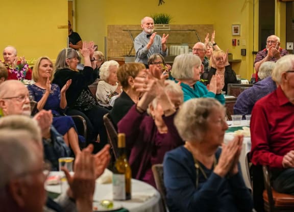 a group of people applauding while sitting in an audience at Winding Commons Senior Living, Carmichael, 95608