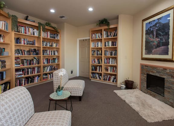 a living room with a fireplace and shelves of books at Castle Vista Senior Duplex Community, Atwater, 95301