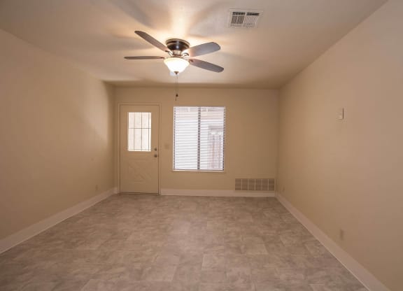 an empty living room with a ceiling fan and a window at Castle Vista Senior Duplex Community, Atwater, CA, 95301