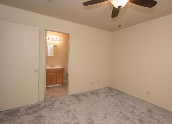 an empty bedroom with a ceiling fan and a bathroom at Castle Vista Senior Duplex Community, Atwater, 95301