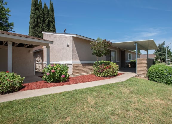 a building with a porch and a lawn in front of it at Castle Vista Senior Duplex Community, Atwater, CA, 95301