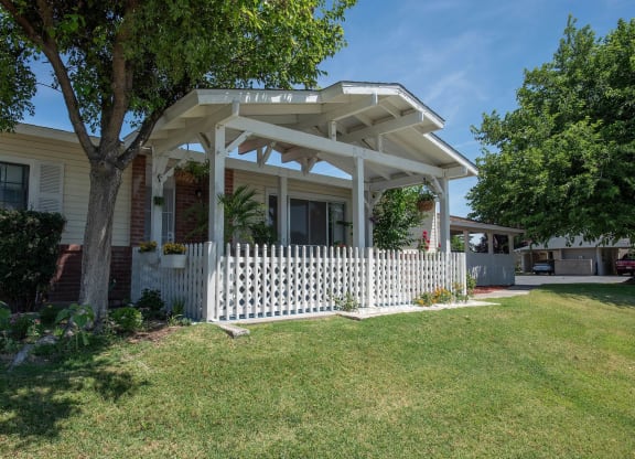 a house with a white porch and a white picket fence at Castle Vista Senior Duplex Community, Atwater, 95301