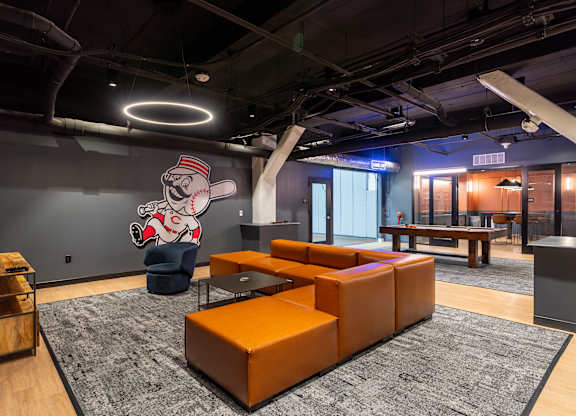 a lobby with orange couches and a mural of a baseball player at Textile Apartments, Cincinnati, OH, 45202
