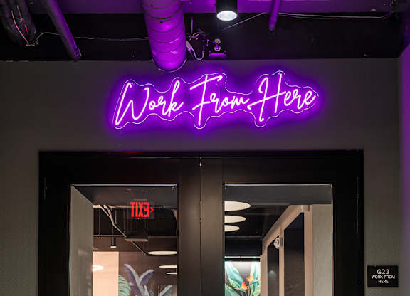 a purple neon sign above a door that reads work from home at Textile Apartments, Cincinnati, OH
