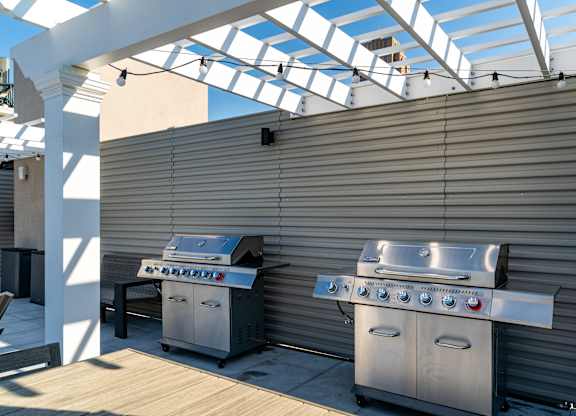 two stainless steel barbecue grills on a patio with a roof at Textile Apartments, Cincinnati, 45202