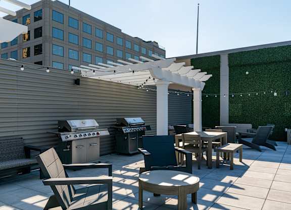 a patio with tables and chairs and a barbecue grill on a roof at Textile Apartments, Ohio, 45202