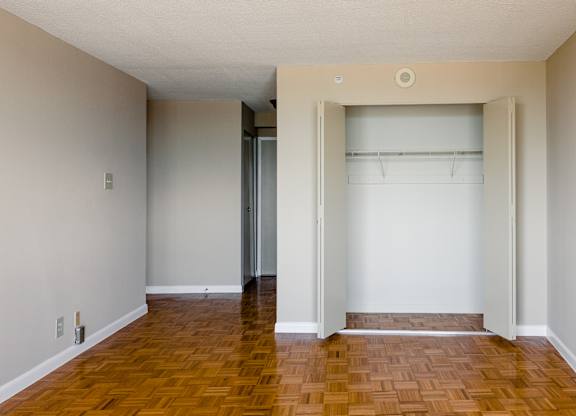 A room with a wooden floor and a white wall at Hampton Plaza Apartments, Towson