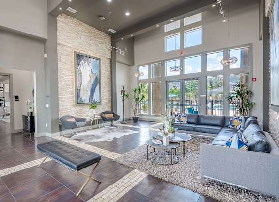 a living room with couches and tables and large windows at Discovery at Craig Ranch, McKinney, Texas