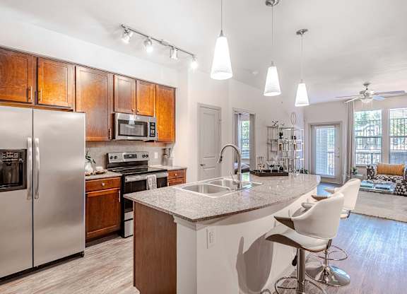 a kitchen with a island and a stainless steel refrigerator at Discovery at Craig Ranch, McKinney