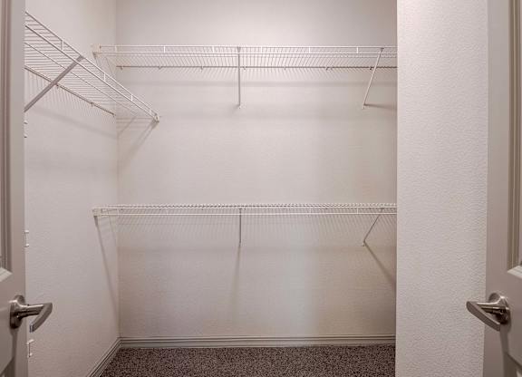 a walk in closet with empty shelves in a white room at Discovery at Craig Ranch, McKinney, Texas