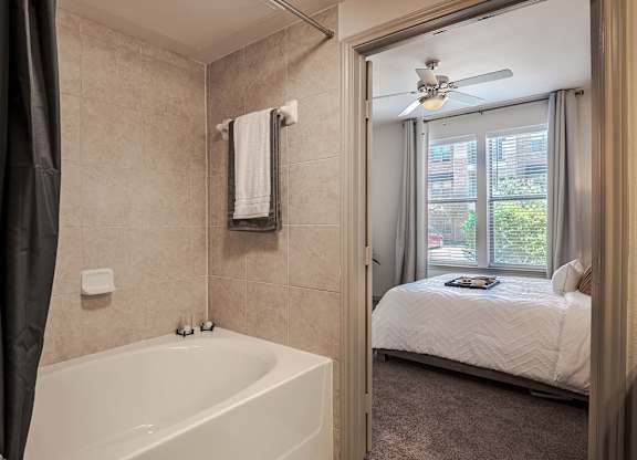 a bathroom with a tub and a bedroom with a bed at Discovery at Craig Ranch, Texas