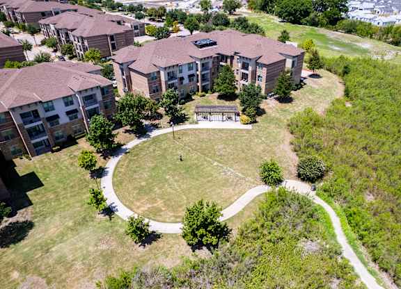 an aerial view of a building with a yard and a pathway at Discovery at Craig Ranch, Texas, 75070