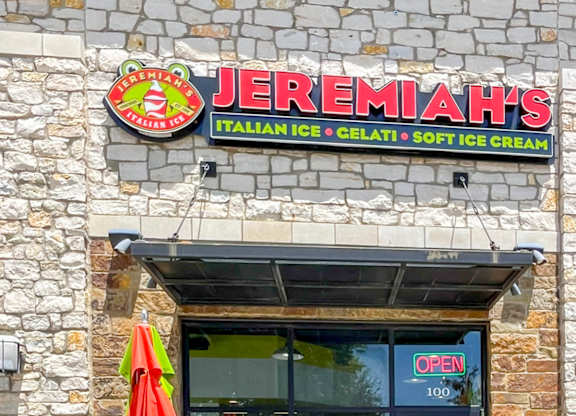 A storefront of Jeremiah's Italian Ice with a red umbrella outside at Craig Ranch, McKinney, TX.