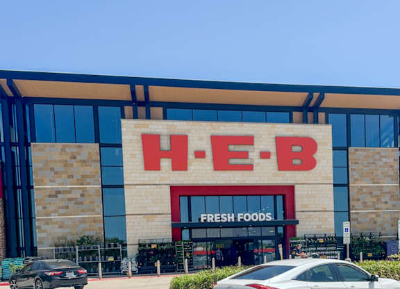The exterior of a HEB grocery store with cars parked in front at Discovery at Craig Ranch, McKinney, 75070.
