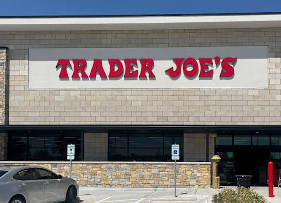 A grey car is parked in front of a Trader Joe's store at Discovery at Craig Ranch, McKinney, 75070.