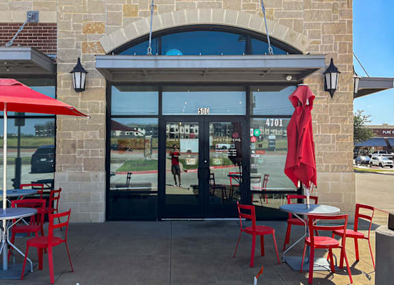 Sweetwaters Coffee & Tea storefront with red umbrellas and chairs at Discovery at Craig Ranch, McKinney, 75070.