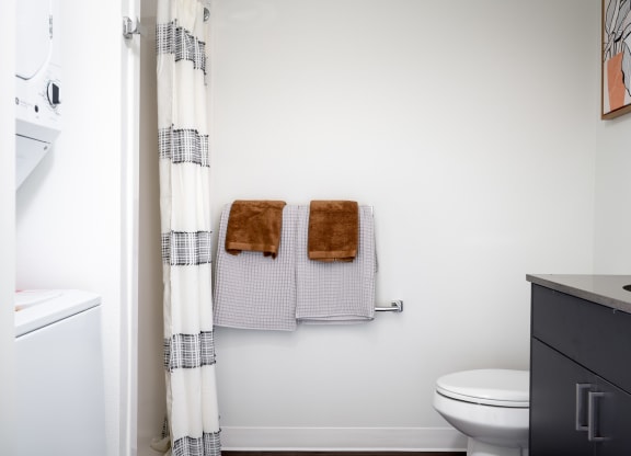 a bathroom with two towels and a toilet and a shower curtain