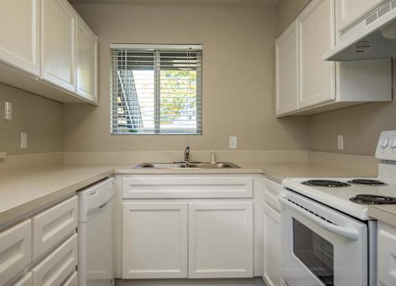 Two Bedroom w/ Den | Kitchen with white cabinets and white appliances.