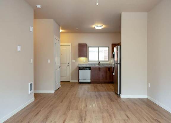 a large empty kitchen with a wooden floor