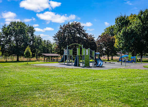 A playground with a green slide and a blue slide.