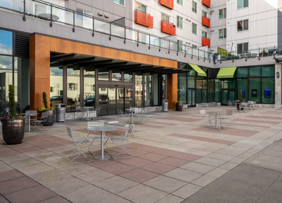 a courtyard with tables and chairs outside of a building