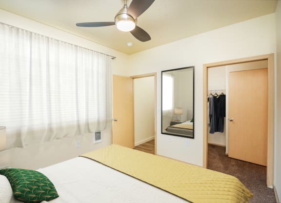 a bedroom with a large bed and a ceiling fan