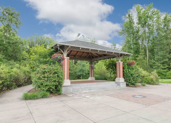 a gazebo with a stone wall and brick pillars