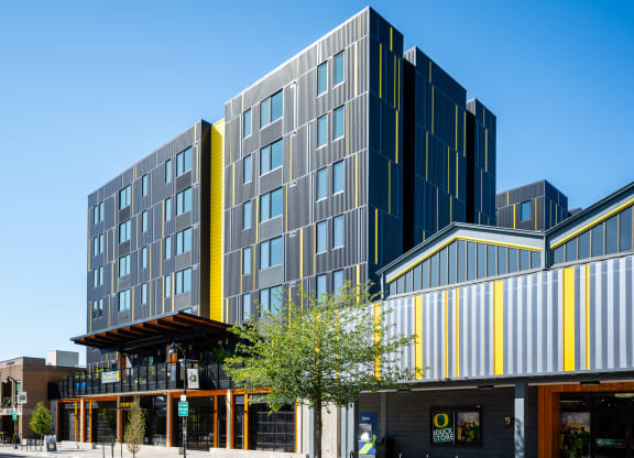 a modern apartment building with a yellow and gray facade in Eugene, Oregon