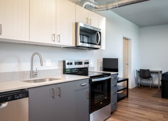 a kitchen with white cabinets and a sink and a microwave