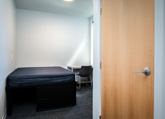 an empty room with a bed and a door