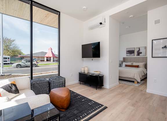 A modern living room with a large window overlooking a street.